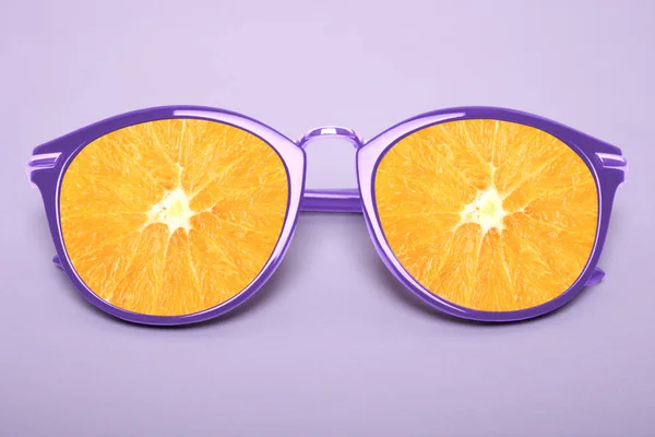 Bright purple sunglasses with orange on a pastel purple background.