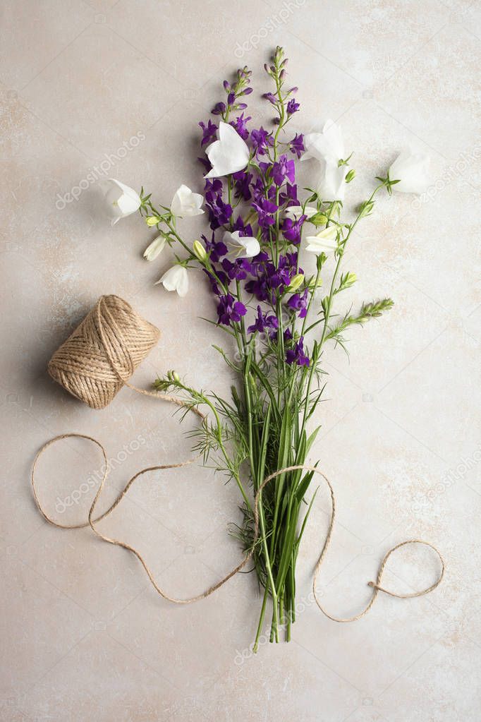 A beautiful bouquet of bellflowers and twine on a neutral background. Top view. 