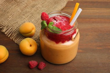 Ahududu ahşap arka plan üzerinde bir cam kavanoza ile kayısı güler yüzlü.