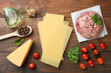 Tahta arka planda İtalyan lazanyası pişirmek için farklı malzemeler. Üst görünüm