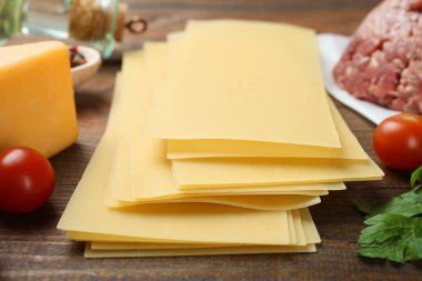 Tahta arka planda İtalyan lazanyası pişirmek için farklı malzemeler..