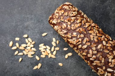 Siyah ekmek ile Ayçiçeği tohumları üzerinde siyah bir arka plan olduğunu. Üstten görünüm
