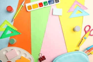 Farklı okul malzemeleri parlak bir arka plan üzerinde bir çerçeveden.