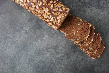 Taze ekmek tohumları ile siyah bir arka plan üzerinde yatıyor.