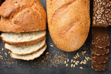Taze ekmek tohumları ile siyah bir arka plan üzerinde yatıyor.