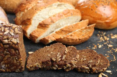 Taze ekmek tohumları ile siyah bir arka plan üzerinde yatıyor.