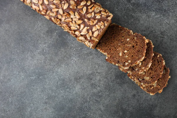 Taze ekmek tohumları ile siyah bir arka plan üzerinde yatıyor.