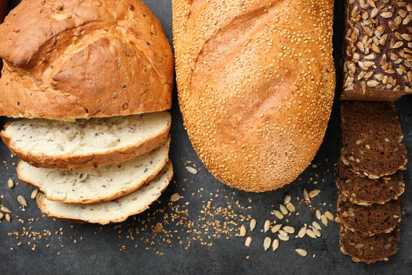 Taze ekmek tohumları ile siyah bir arka plan üzerinde yatıyor.