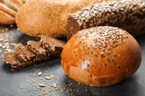 Taze ekmek tohumları ile siyah bir arka plan üzerinde yatıyor.