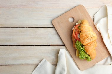 Kruvasan sebze kesme tahtası ahşap zemin ile.