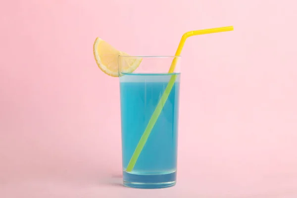 蓝色泻湖的酒精鸡尾酒与一片柠檬在一个粉红色的背景玻璃上 — 图库照片