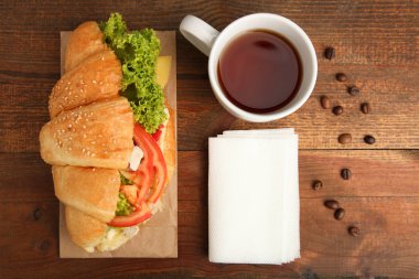 Kruvasan sebze ve bir fincan çay bir ahşap zemin üzerinde. Üstten görünüm.