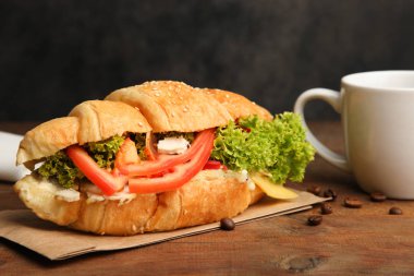 Kruvasan sebze ve bir fincan çay siyah bir zemin üzerine ahşap bir masa üzerinde.