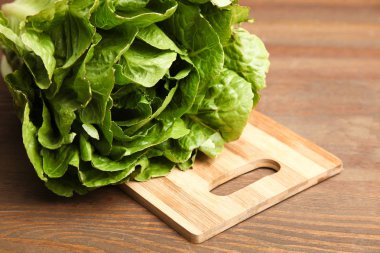 Ahşap arka plan üzerinde kesme tahtası üzerinde bir taze salata marul.