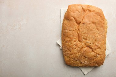 Geleneksel İtalyan ciabatta ekmeği tarafsız bir arka plan üzerine bir havlu üzerinde. Üstten görünüm.