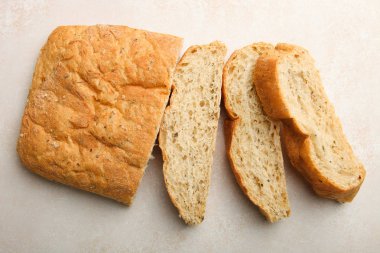 Geleneksel İtalyan ciabatta ekmeği tarafsız bir arka plan üzerinde yatıyor. Üstten görünüm.