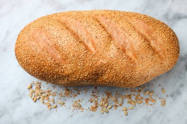 Mermer zemin üzerine tohumları ile taze beyaz ekmek. Kavram ekmek