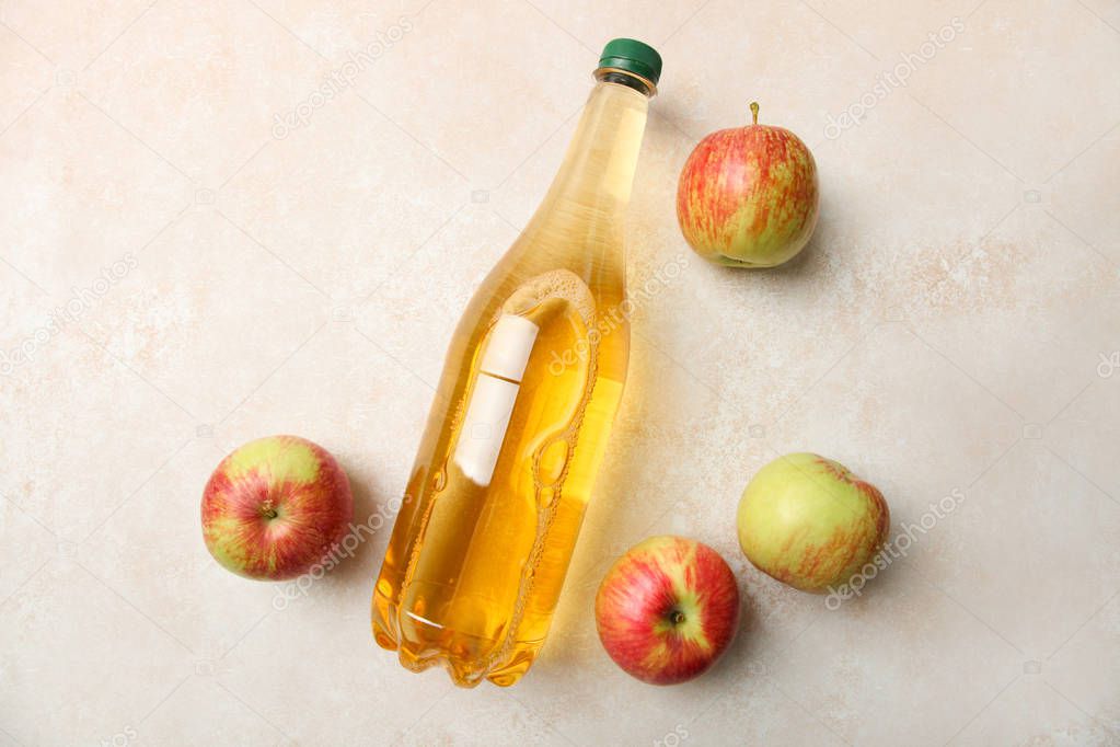 Apple cider in bottle and apples on neutral background. Top view. Concept alcoholic beverage.