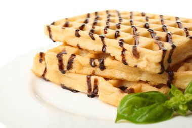 Belçika waffle çikolata üzerinde beyaz izole fesleğen ile. Kavram tatlı.