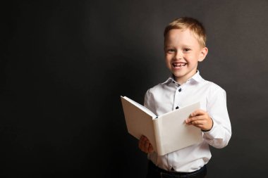 Siyah arka plan üzerine kitap ile okul çocuğu. Kavram okul.