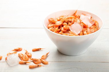 Ahşap arka plan üzerinde kase haşlanmış, soğutulmuş karides. Kavram deniz ürünleri.