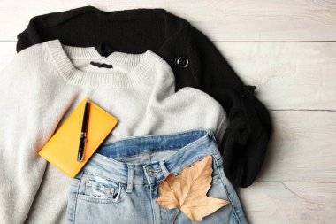 Sonbahar giysileri ve defter kalem ahşap arka plan üzerinde ile.