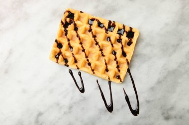 Belçika waffle mermer zemin üzerine çikolata tepesi ile. Kavram tatlı. Üstten görünüm.