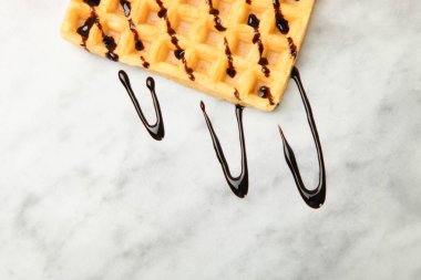 Belçika waffle mermer zemin üzerine çikolata tepesi ile. Kavram tatlı. Üstten görünüm.