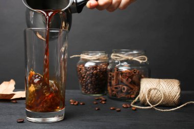 Sıcak kahve cam siyah arka plan üzerine dökülür.