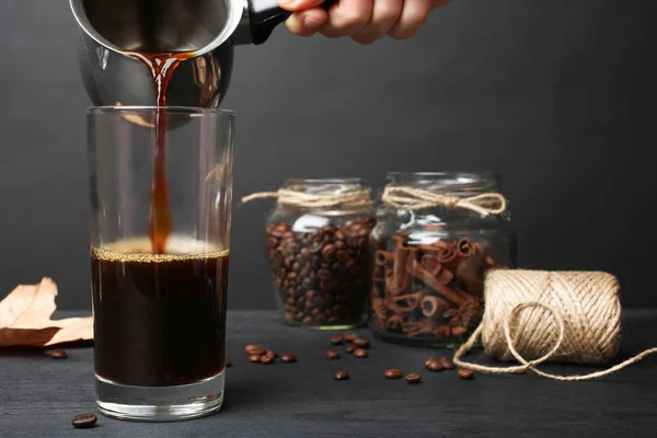 stock image Hot coffee poured in glass on black background.