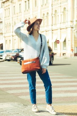 Şapka ve çanta şehirde sonbahar giysileri kızı.