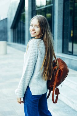 Kız sıcak kazak ve kot City sırt çantası ile. Kavram sonbahar kıyafetleri.