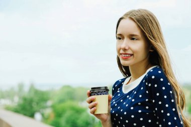Dinlenme ve gökyüzü karşı kahve içme güzel kız.