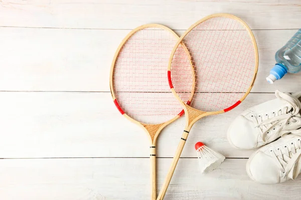 Raquetes Vaivém Sapatos Esportivos Fundo Madeira Conceito Badminton — Fotografia de Stock