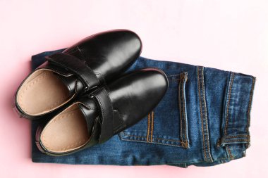 Siyah klasik Ayakkabı ve kot pembe bir arka plan üzerinde. Kavram kıyafetler. Üstten görünüm.