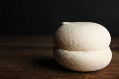 Zephyr zevkli Latte üzerinde siyah bir zemin üzerine ahşap bir masa. Kavram tatlılar.