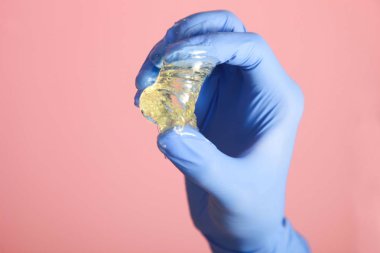 Şeker yapıştırma için epilasyon elinde pembe bir arka plan üzerinde. Kavram shugaring.