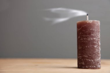 Gri arka plan üzerinde ahşap masa üzerinde bir güzel mum.