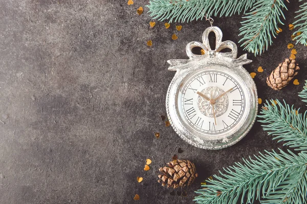 Old clock and pine branch on black background. Concept New Year.