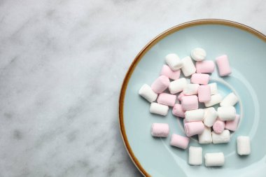 Plaka mermer zemin üzerine marshmallow ile. Üstten görünüm, kopya alanı.