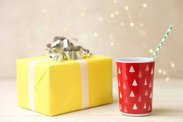 Taza Plástico Rojo Regalo Amarillo Sobre Fondo Neutro Concepto Navidad — Foto de Stock