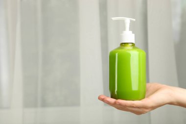 Nötr arka plan üzerinde eller için yeşil sıvı sabun. Kavram hijyen.