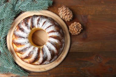 Ahşap arka plan üzerinde koniler ile Noel Kek Kesme tahtası ve köknar dalı. Üstten görünüm, kopya alanı.