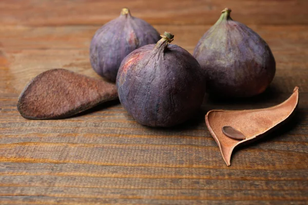 三个完整的成熟紫色无花果在木背景 健康的食物 复制空间 — 图库照片
