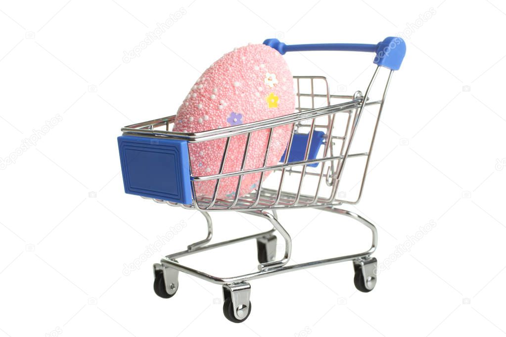 One grocery trolly with one bright beautiful pink easter egg isolated on white. Concept Easter.
