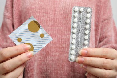 Tutan eller oral kontraseptif hap ve prezervatif, seçim kadın. Kavram kadın hastalıkları, cinsel eğitim.