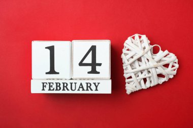 Ahşap takvim tarihi 14 Şubat ve parlak kırmızı zemin üzerine beyaz dekoratif kalp ile. Kavram Sevgililer günü, aşk.
