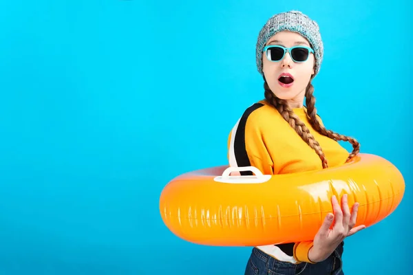 Překvapen Dívka Zimní Oblečení Nafukovací Oranžový Kruh Plavání Modrém Pozadí — Stock fotografie