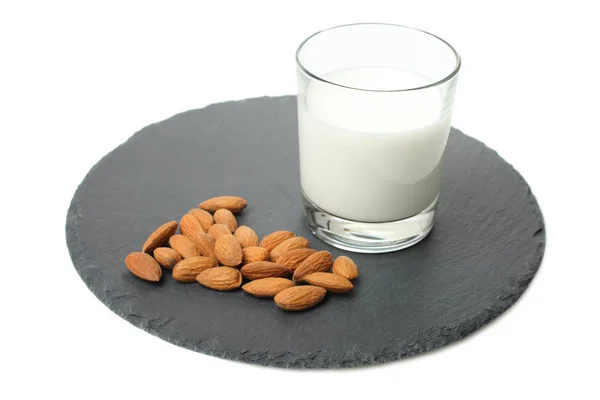 Glas Mit Milch Und Mandelnüssen Auf Schiefertafel Isoliert Auf Weiß — Stockfoto