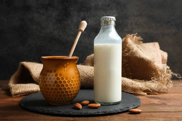 Bottle Milk Jar Honey Almond Nuts Slate Board Wooden Table — Stock Photo, Image